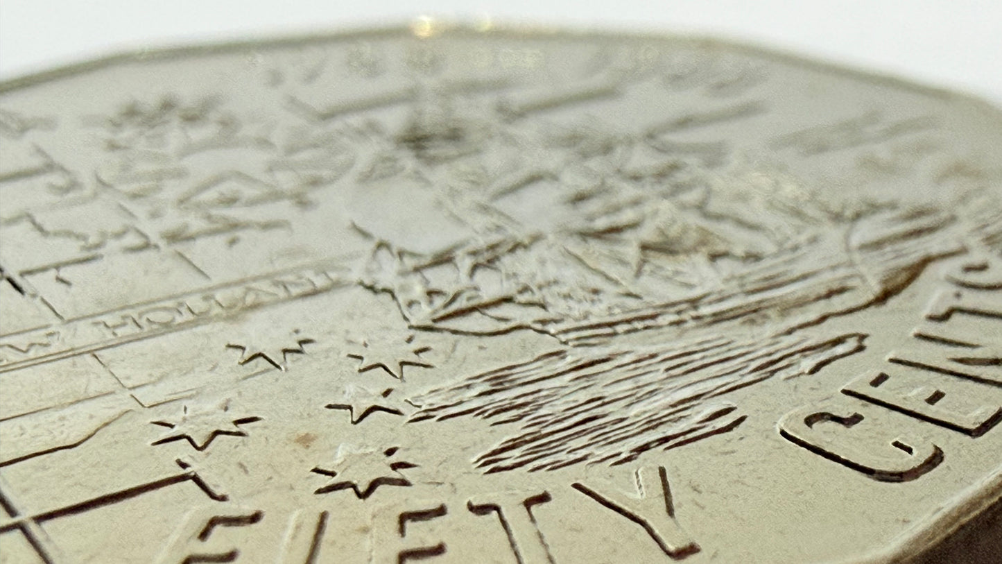 Close-up of a coin with detailed engravings on a white background