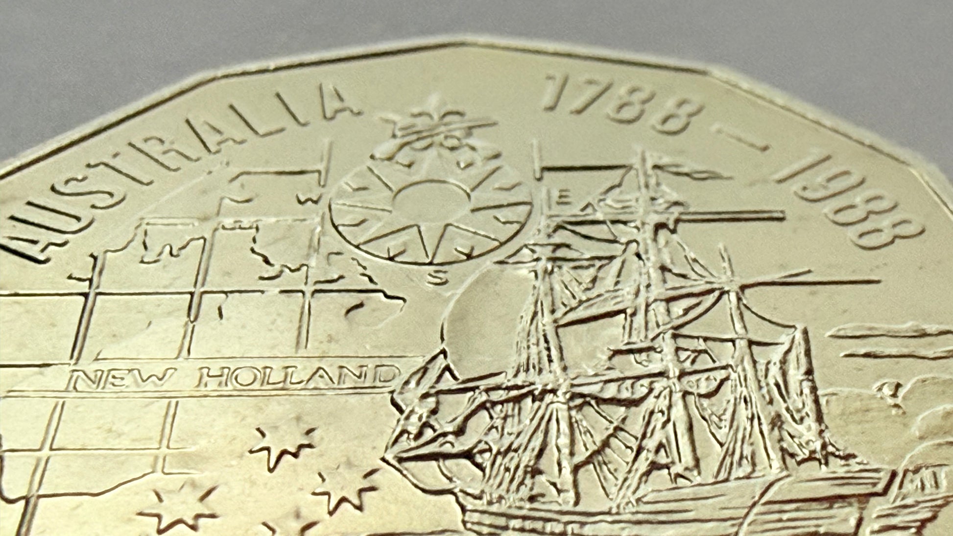 Close-up of a coin commemorating Australia's 1788-1988 anniversary with a ship and map design.