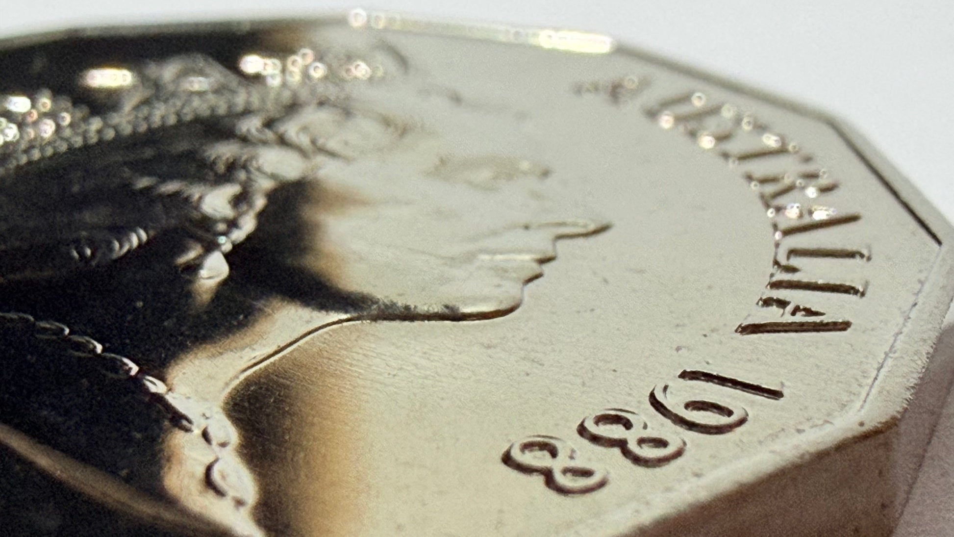 Close-up of a silver coin with a profile portrait and '1988' inscription.