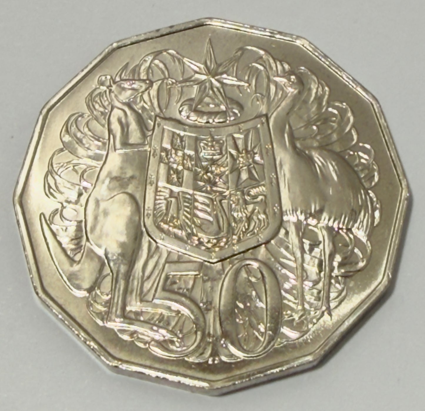 Silver coin with a design of kangaroos and a shield on a gray background